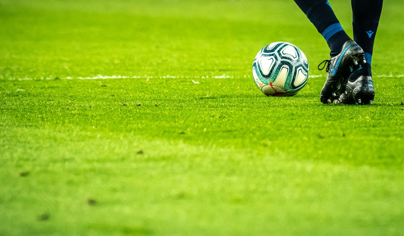 Joueur frappant un ballon sur un terrain de football